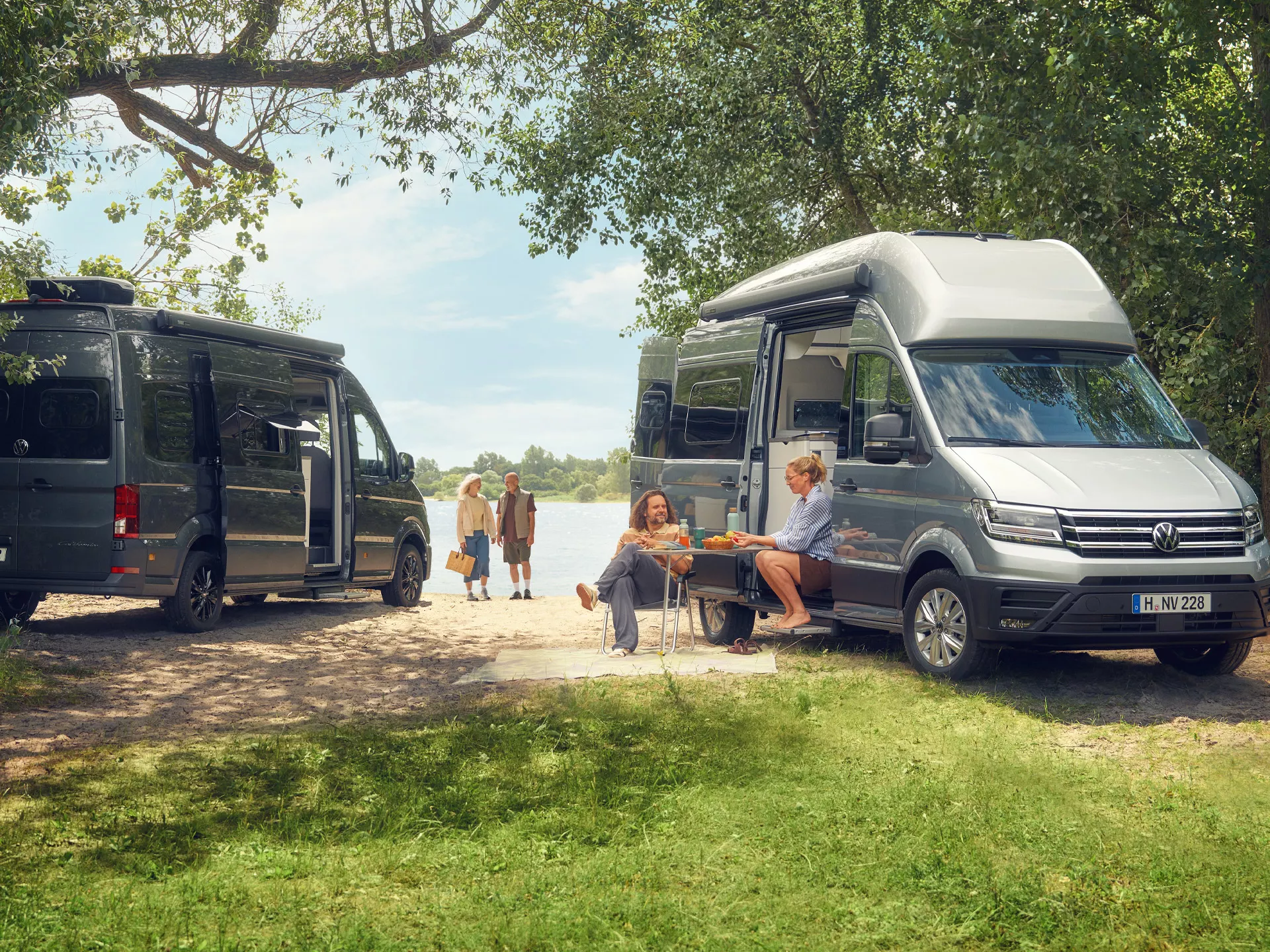 Menschen vor dem Volkswagen Grand California in der Natur